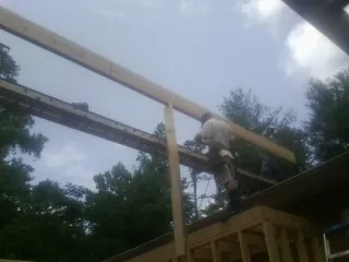 Carpenter setting a ridge beam over a new addition frame — Ice Dam Removal by Roofing Brothers in Huson