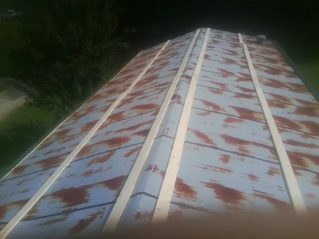Rusted metal roof panels with new wood purlins before replacement — Storm Damage Roof Repair in Huson by Roofing Brothers