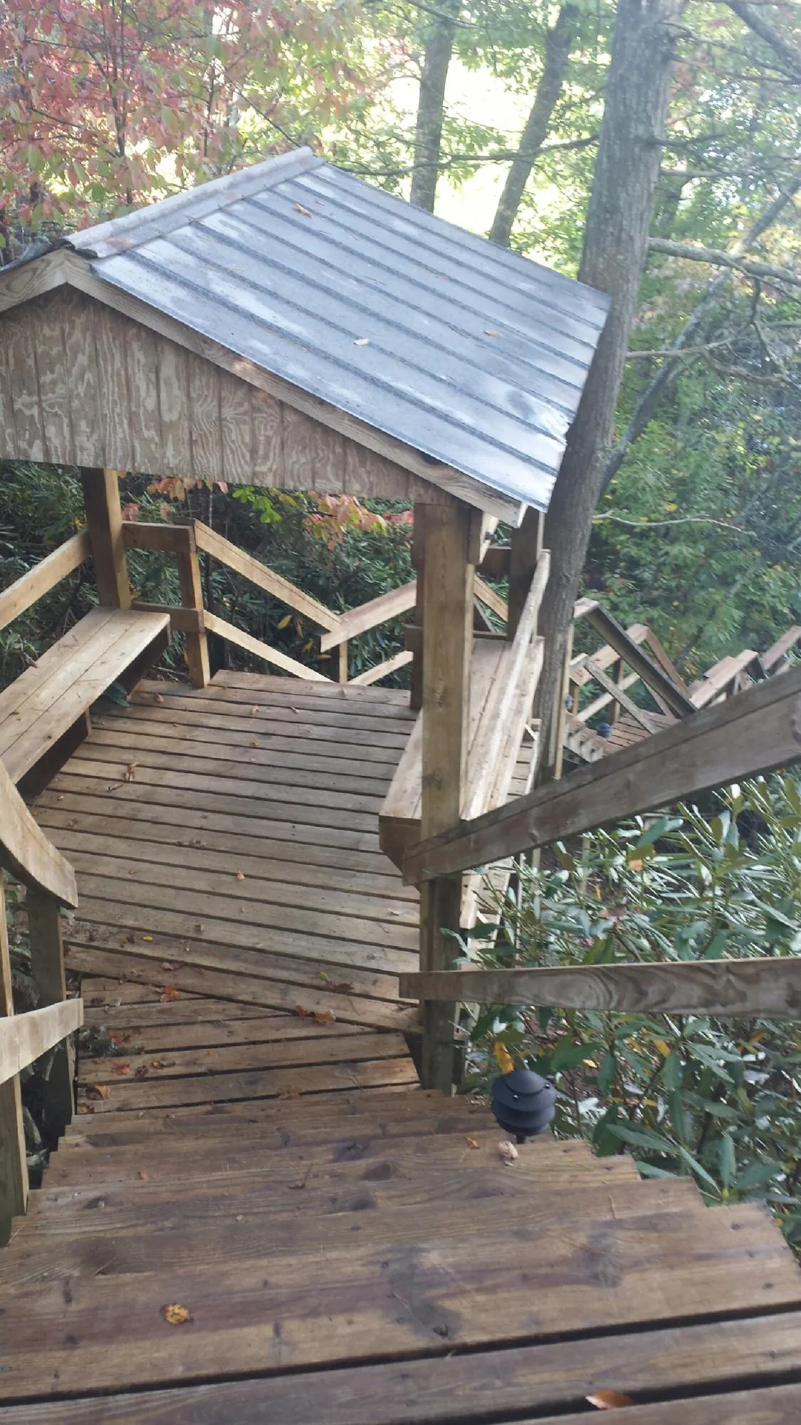 Metal roofed shelter over wooden steps on a wooded walkway — Skylight Repair & Installation work by our crew in Huson