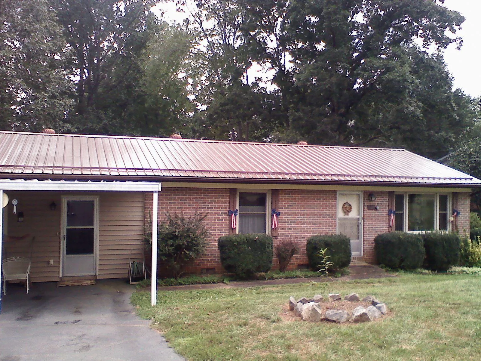 Bronze metal roof and carport on a brick ranch home — Roof Repair work by our crew in Huson